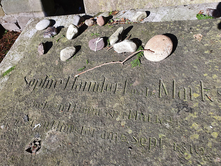 Kleine Gedenksteine liegen auf dem Grabmal für Sophie und Alexander Haindorf